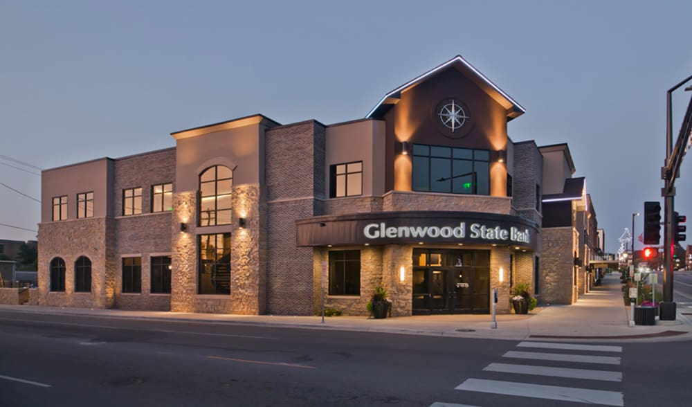 A modern two-story brick building at dusk with illuminated 