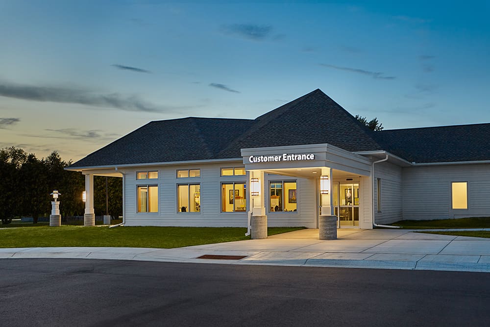 A well-lit building at dusk in Waite Park with large windows and a sign above the entrance that reads 
